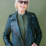 Trendy senior happy woman in sunglasses and stylish leather jacket